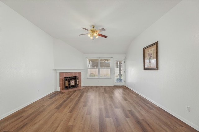 unfurnished living room with vaulted ceiling, ceiling fan, hardwood / wood-style floors, and a tile fireplace