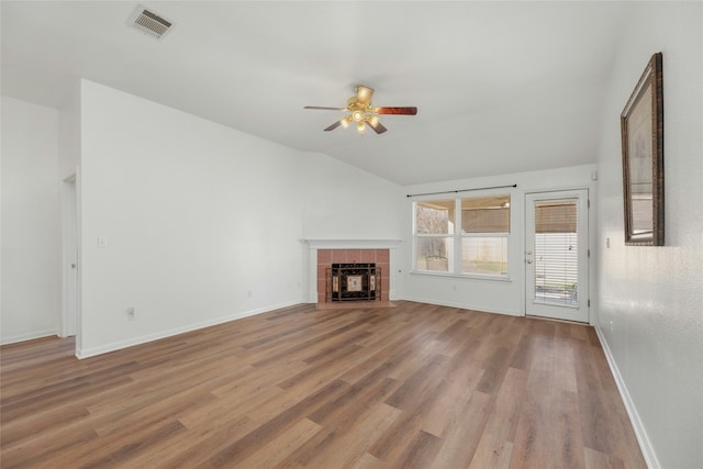 unfurnished living room with vaulted ceiling, ceiling fan, a fireplace, and hardwood / wood-style floors