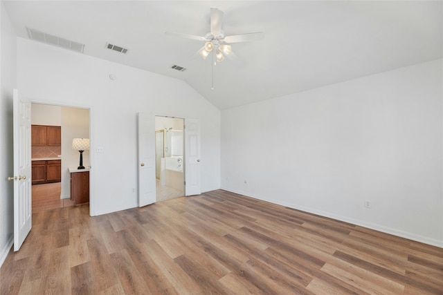 unfurnished bedroom featuring ceiling fan, vaulted ceiling, connected bathroom, and light hardwood / wood-style floors