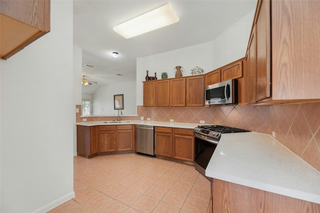 kitchen with light tile patterned floors, kitchen peninsula, ceiling fan, stainless steel appliances, and sink