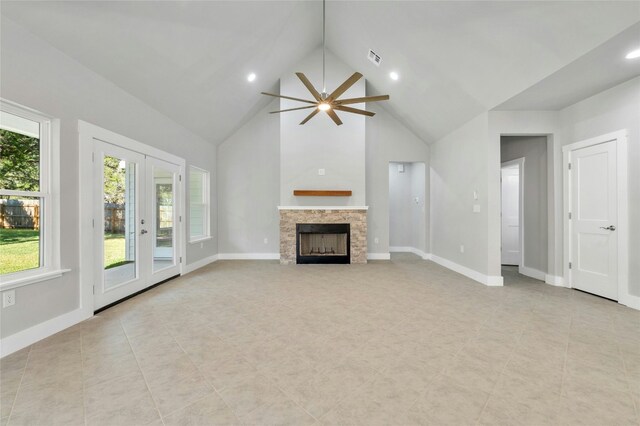 unfurnished living room featuring french doors, high vaulted ceiling, a stone fireplace, and ceiling fan