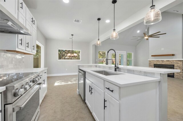 kitchen with sink, hanging light fixtures, an island with sink, extractor fan, and appliances with stainless steel finishes