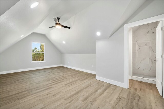 additional living space with ceiling fan, light hardwood / wood-style floors, and vaulted ceiling