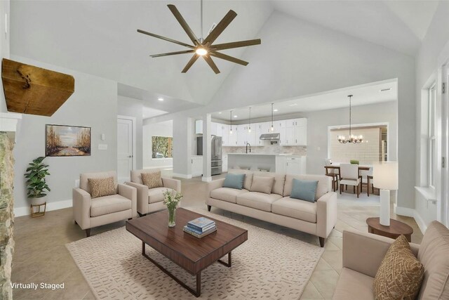 living room with high vaulted ceiling, light tile patterned flooring, and ceiling fan with notable chandelier