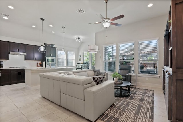 living room featuring ceiling fan, light tile patterned floors, and lofted ceiling