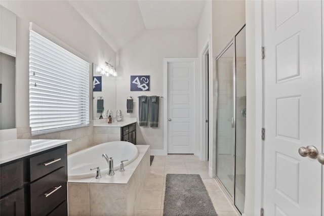 bathroom with tile patterned flooring, vanity, shower with separate bathtub, and vaulted ceiling