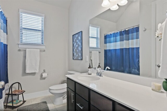 bathroom with tile patterned floors, a healthy amount of sunlight, vaulted ceiling, and toilet