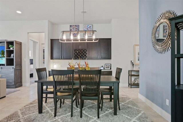 dining area featuring light tile patterned flooring and a notable chandelier