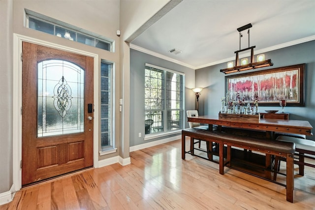 foyer entrance with light wood-type flooring and crown molding