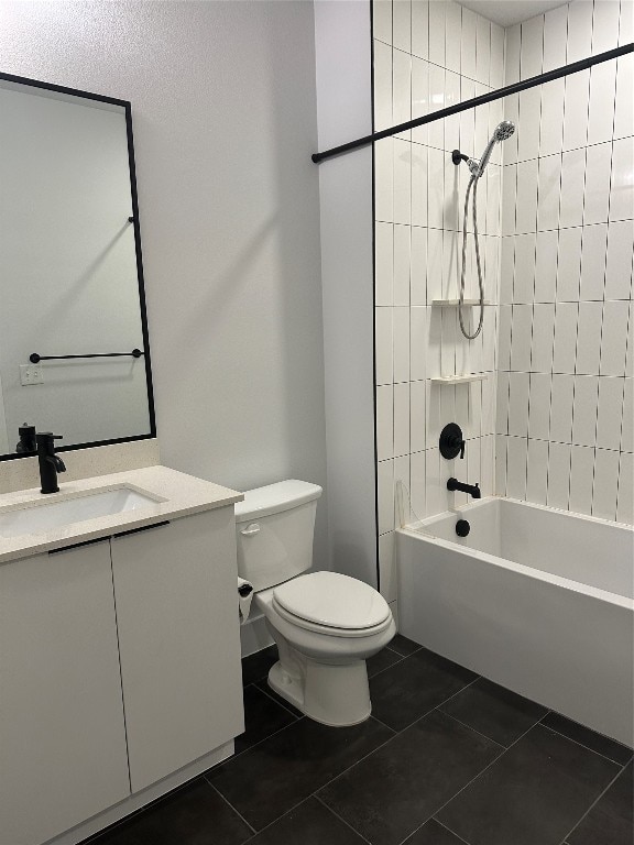 full bathroom featuring tiled shower / bath, tile patterned flooring, vanity, and toilet