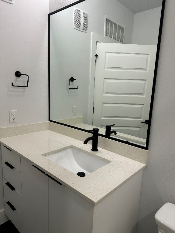 bathroom with vanity and toilet