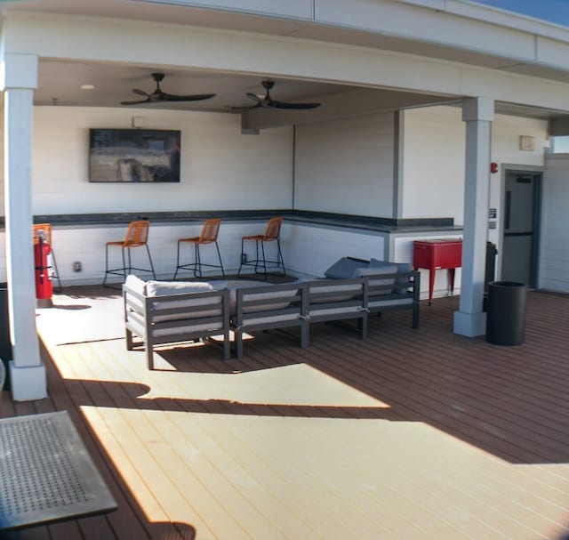 wooden terrace with a bar and ceiling fan