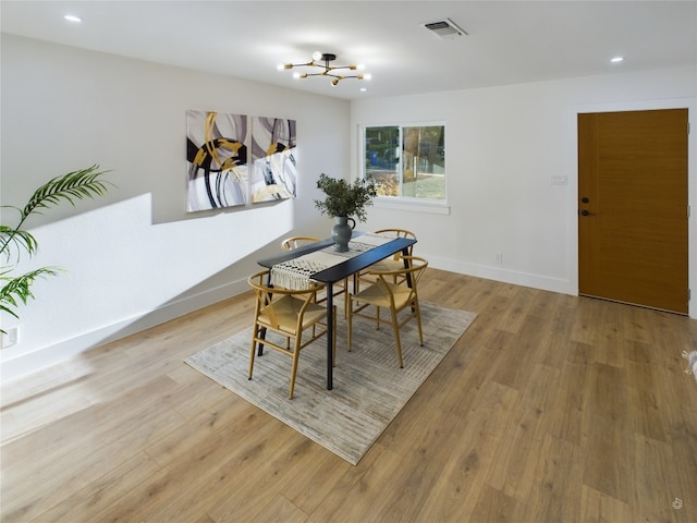 dining area featuring a notable chandelier and light wood-type flooring