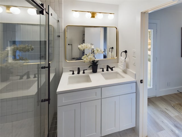 bathroom featuring hardwood / wood-style flooring, vanity, and a shower with door