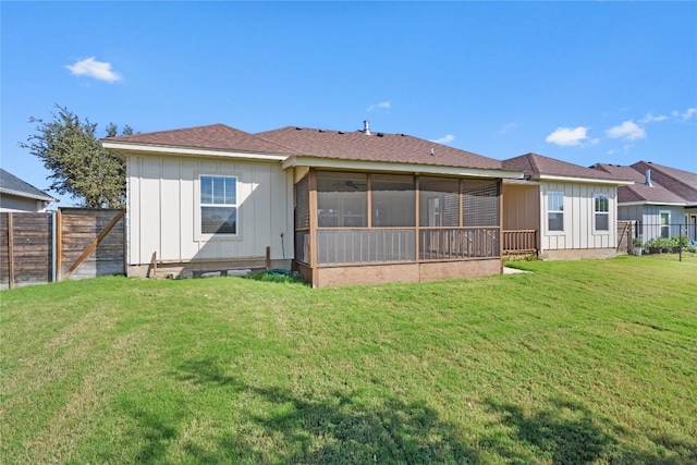 back of house with a sunroom and a yard