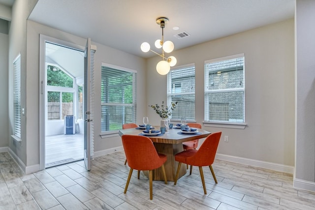 dining area with light wood-type flooring and a chandelier