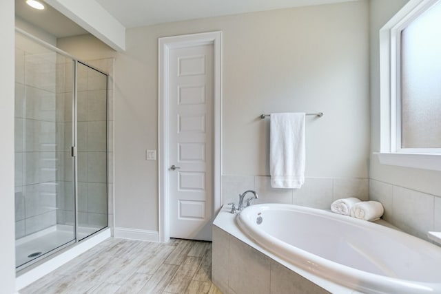 bathroom featuring hardwood / wood-style floors and plus walk in shower