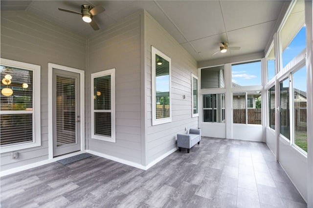 unfurnished sunroom featuring ceiling fan