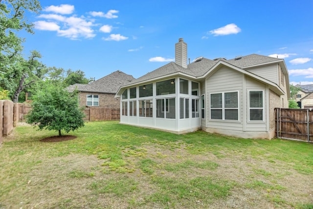 rear view of house with a sunroom and a lawn