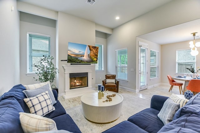 living room with an inviting chandelier and light wood-type flooring