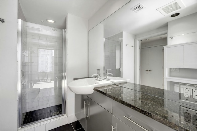 bathroom featuring vanity, tile patterned floors, and a shower with door