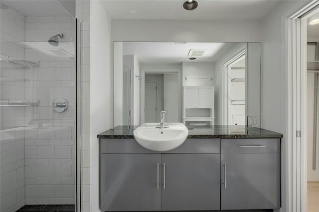 bathroom featuring a tile shower and vanity