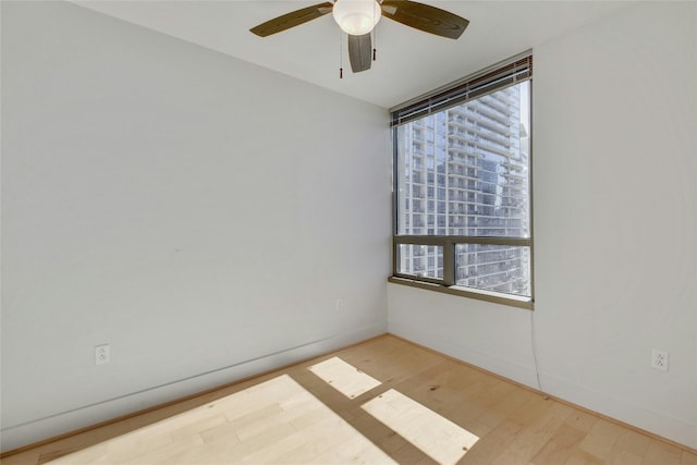 spare room featuring a wealth of natural light, ceiling fan, and light hardwood / wood-style floors