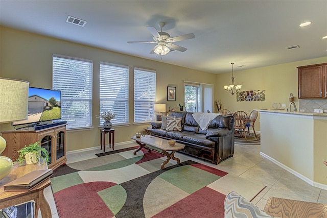 living room featuring ceiling fan with notable chandelier and light tile patterned floors