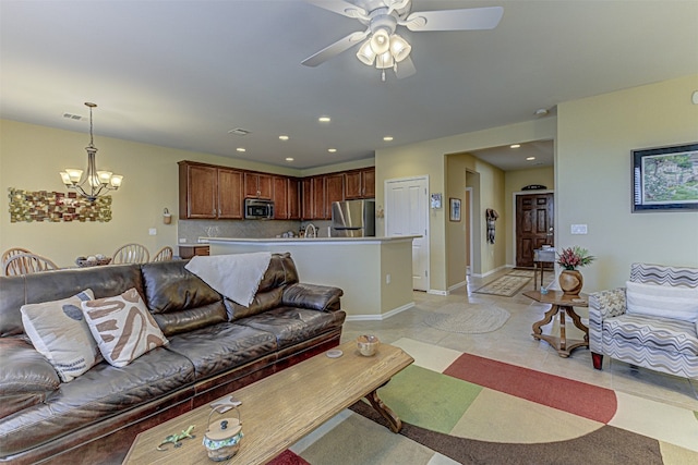 living room with ceiling fan with notable chandelier