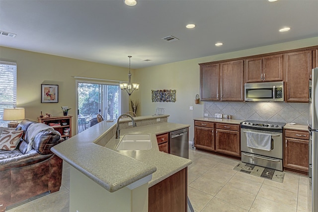 kitchen featuring appliances with stainless steel finishes, sink, plenty of natural light, and an island with sink