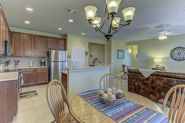 dining area featuring ceiling fan with notable chandelier, light tile patterned floors, and sink