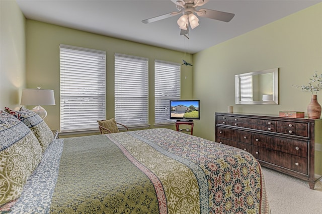 bedroom featuring carpet flooring, ceiling fan, and multiple windows