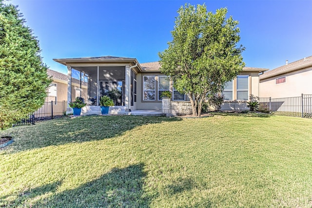 back of property with a yard and a sunroom