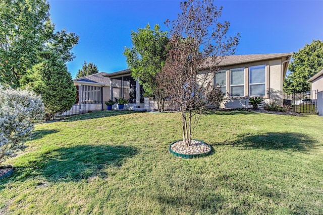 view of front of house with a sunroom and a front lawn