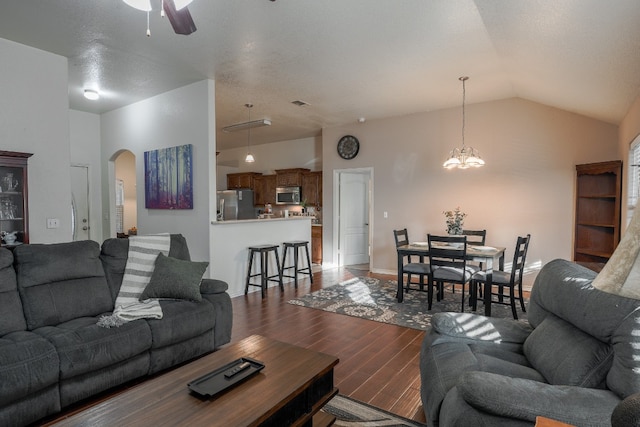 living room featuring vaulted ceiling, a textured ceiling, ceiling fan with notable chandelier, and dark hardwood / wood-style floors