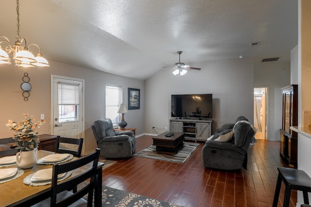 living room with ceiling fan with notable chandelier, a textured ceiling, dark hardwood / wood-style floors, and vaulted ceiling