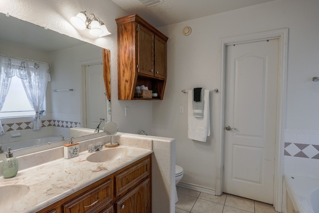 bathroom with tile patterned floors, a textured ceiling, toilet, a bathtub, and vanity