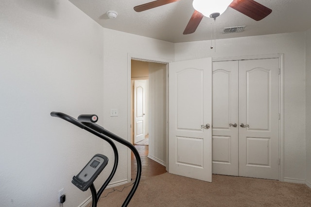 exercise room featuring light carpet