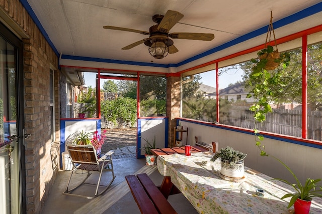 unfurnished sunroom with ceiling fan