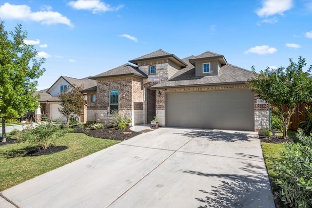 prairie-style home featuring a garage and a front lawn