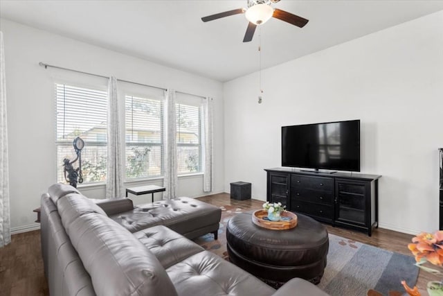 living area featuring plenty of natural light, a ceiling fan, and baseboards