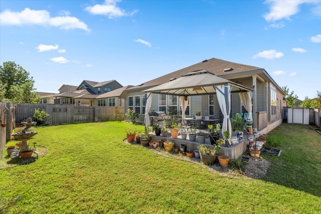 back of property featuring a gazebo, a storage unit, and a lawn