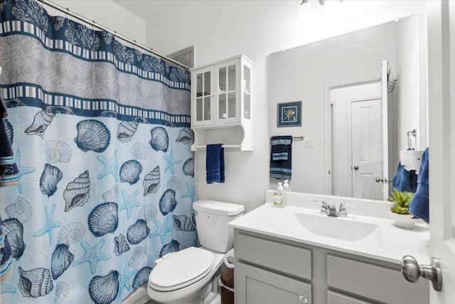 bathroom with curtained shower, vanity, and toilet