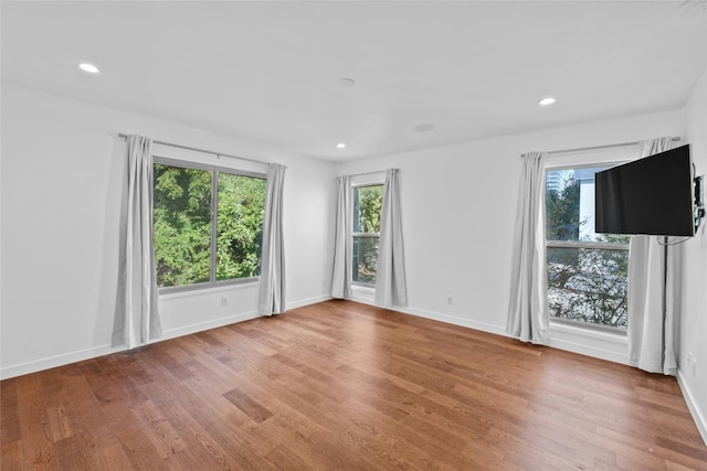 unfurnished room with hardwood / wood-style flooring