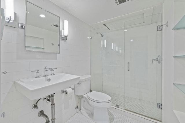 bathroom featuring backsplash, tile walls, tile patterned flooring, toilet, and a shower with shower door