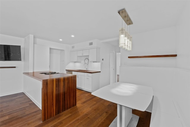 kitchen with decorative light fixtures, white cabinetry, dark wood-type flooring, and sink