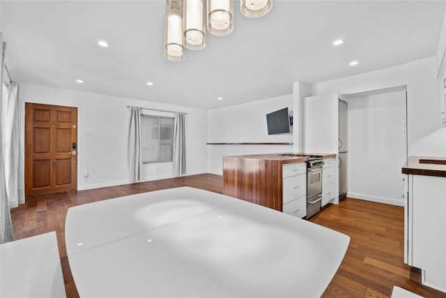 kitchen with hardwood / wood-style flooring, white cabinetry, and stainless steel stove