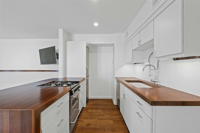 kitchen featuring sink, stainless steel stove, wood counters, dark hardwood / wood-style flooring, and white cabinets