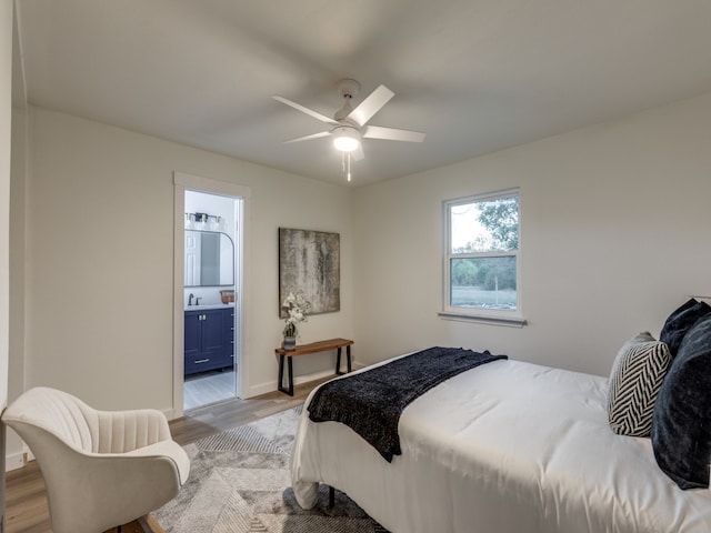 bedroom with ensuite bathroom, ceiling fan, light hardwood / wood-style floors, and sink