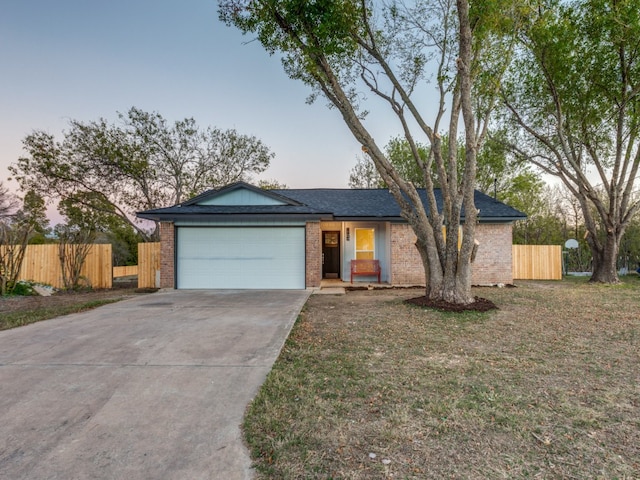 ranch-style house featuring a yard and a garage